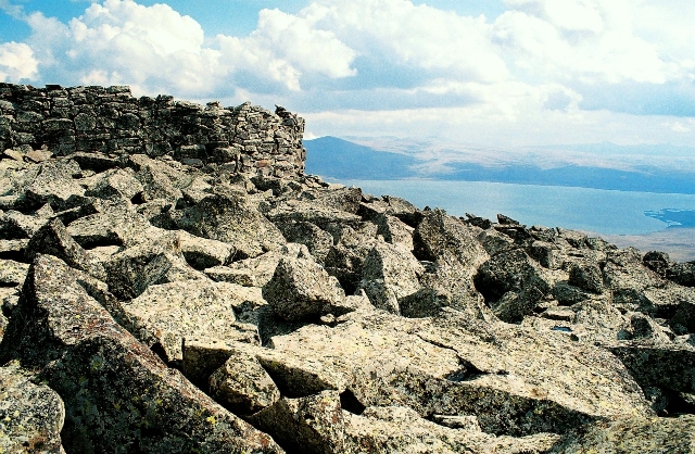 The cyclopean stone walls of Shaori Fortress on a boulder-strewn ridge, with Paravani Lake below