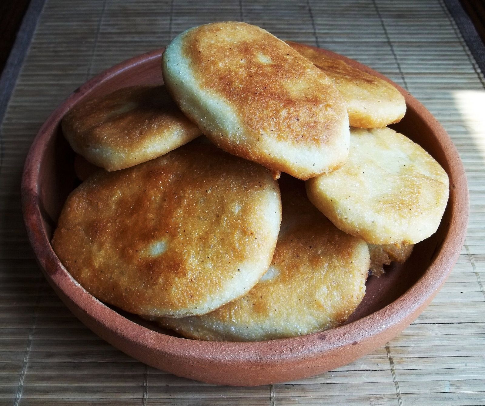 Mchadi, small rounds of golden Georgian cornbread, piled in a clay dish
