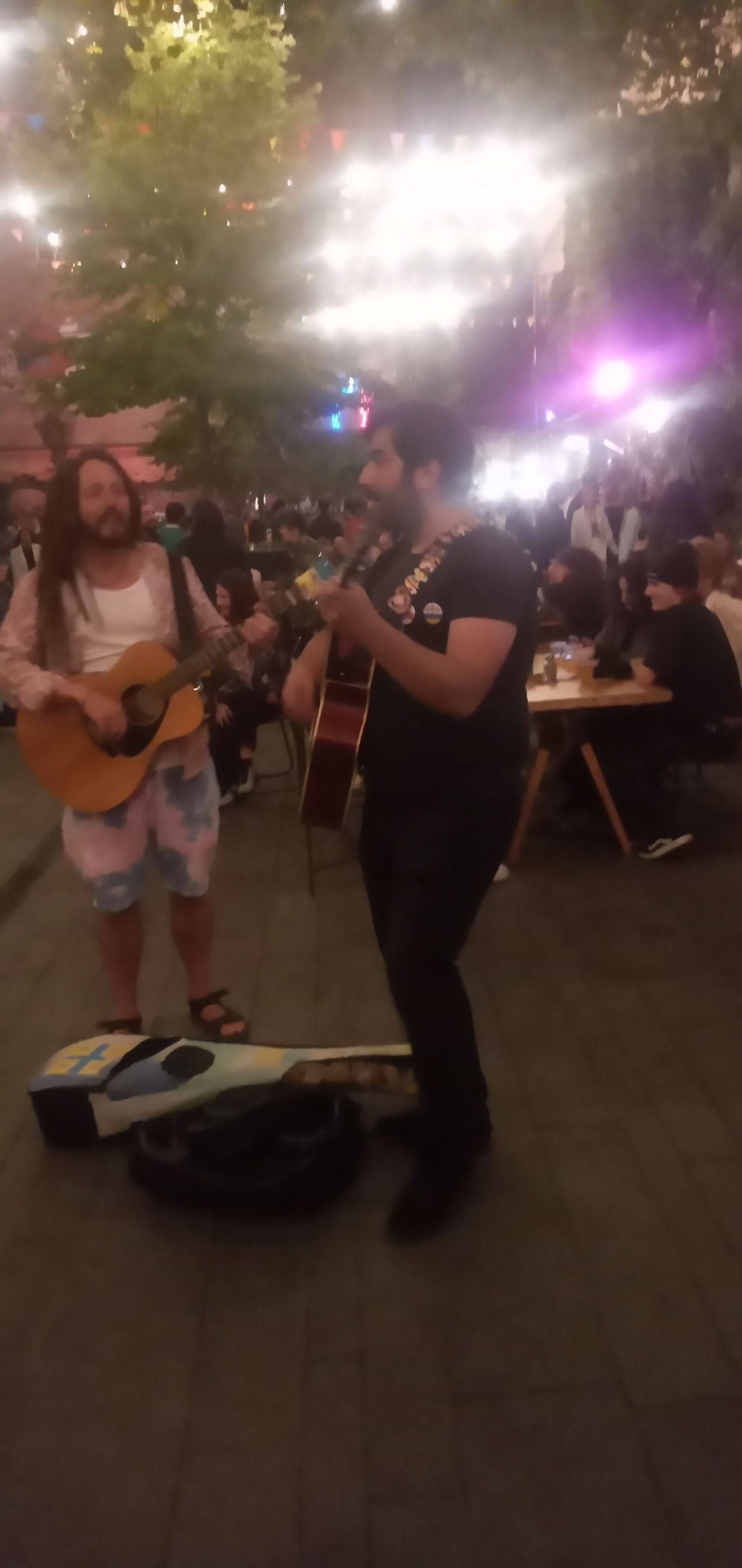 Two street musicians with guitars playing in the Fabrika courtyard on a Saturday night