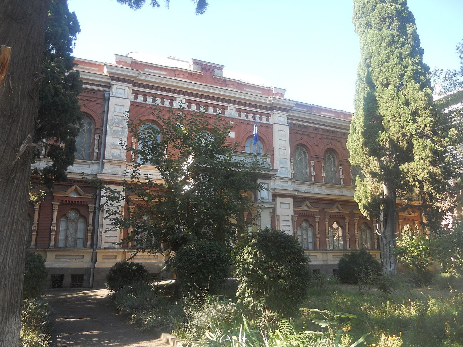 The red-brick 19th-century building of the State Silk Museum in Tbilisi, seen through the trees of its garden
