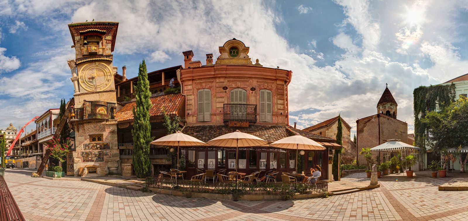 The square on Shavteli Street with the Gabriadze theatre, its leaning clock tower and the cafe terrace under white umbrellas