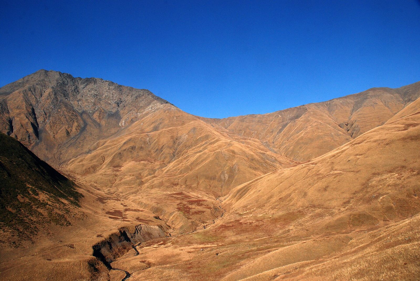 The hiking trail to Sadzele Pass above Juta in the Kazbegi region, with Mount Roshkakhorkhi on the left