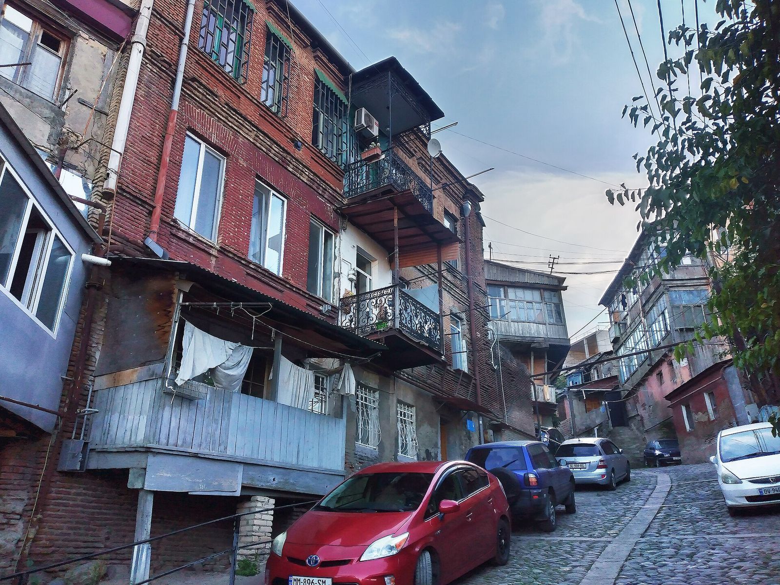 A steep cobbled lane lined with old brick houses and balconies on Gerzel Baazov Street in Old Tbilisi