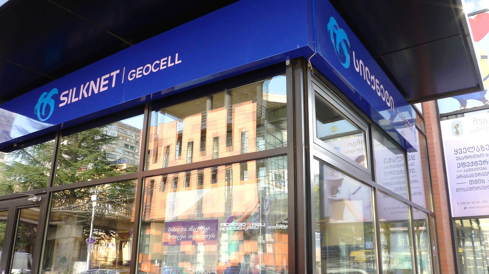 A Silknet service center with Silknet and Geocell signs above its glass front