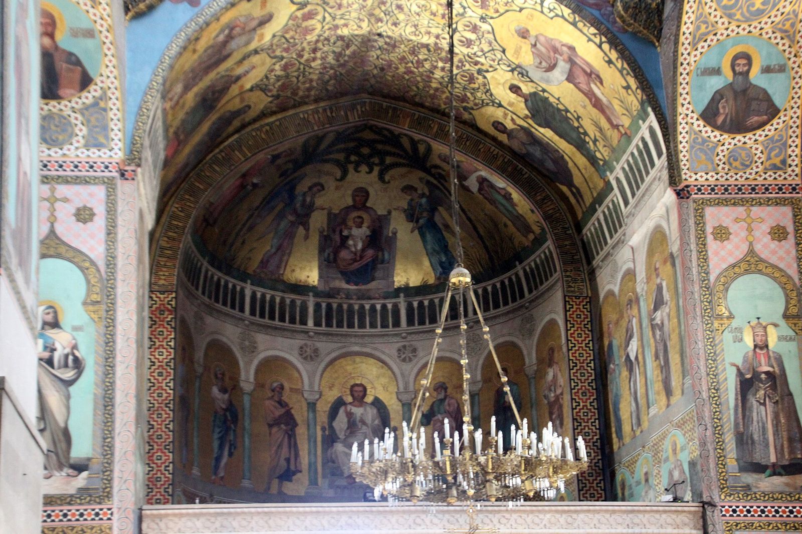 The painted apse of Sioni Cathedral in Tbilisi, with gold-ground frescoes of saints above a candle chandelier
