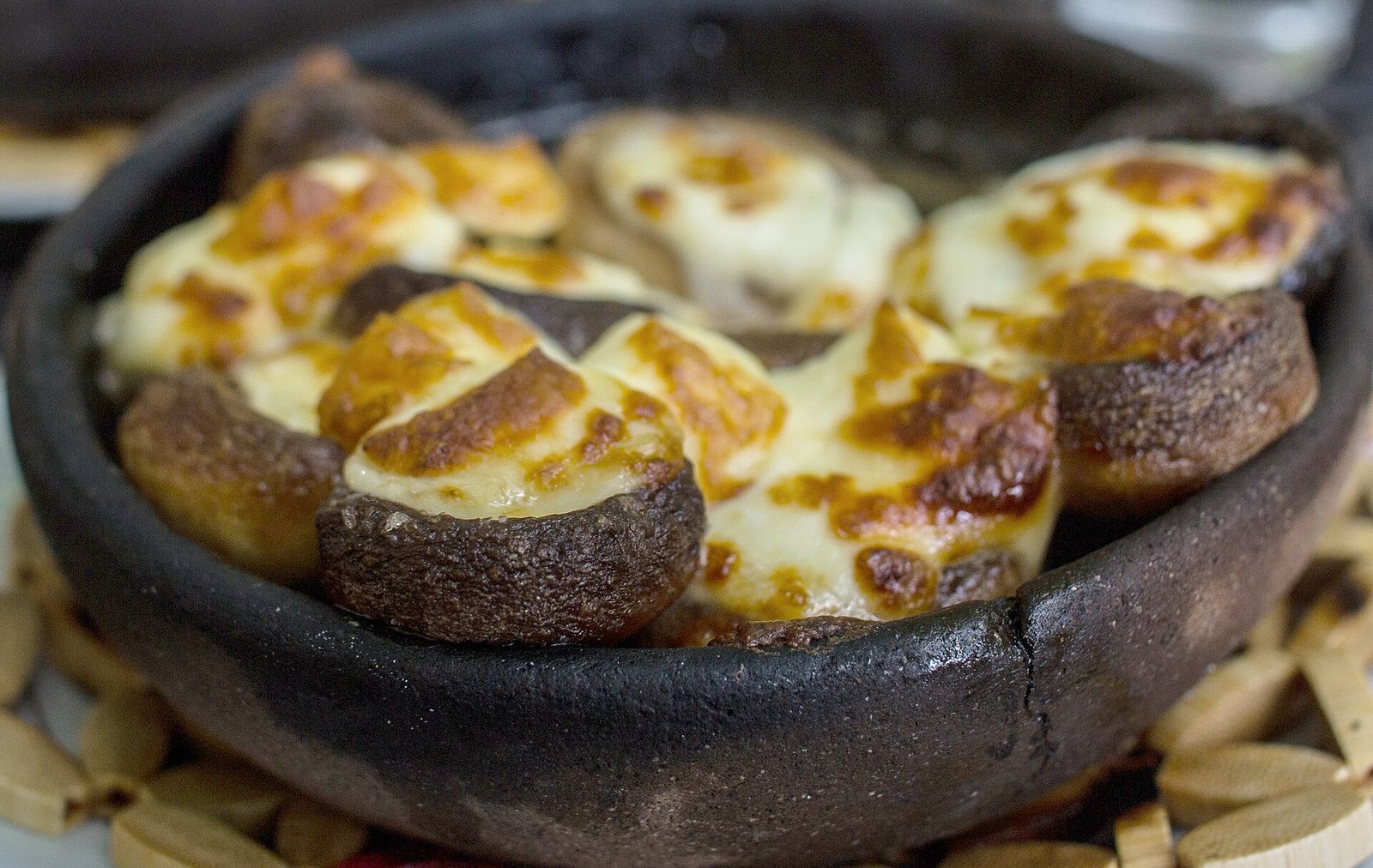 Mushroom caps filled with sulguni and baked until the cheese browns, in a blackened clay dish in Georgia