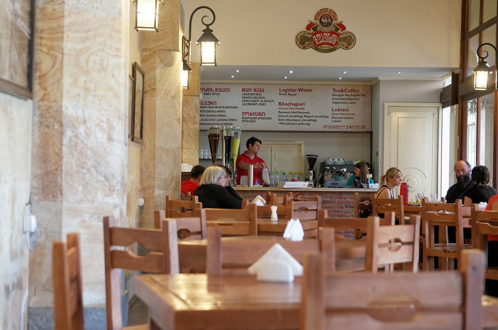 Inside a Lagidze Water cafe in Tbilisi, with the syrup dispensers on the counter and the menu board above