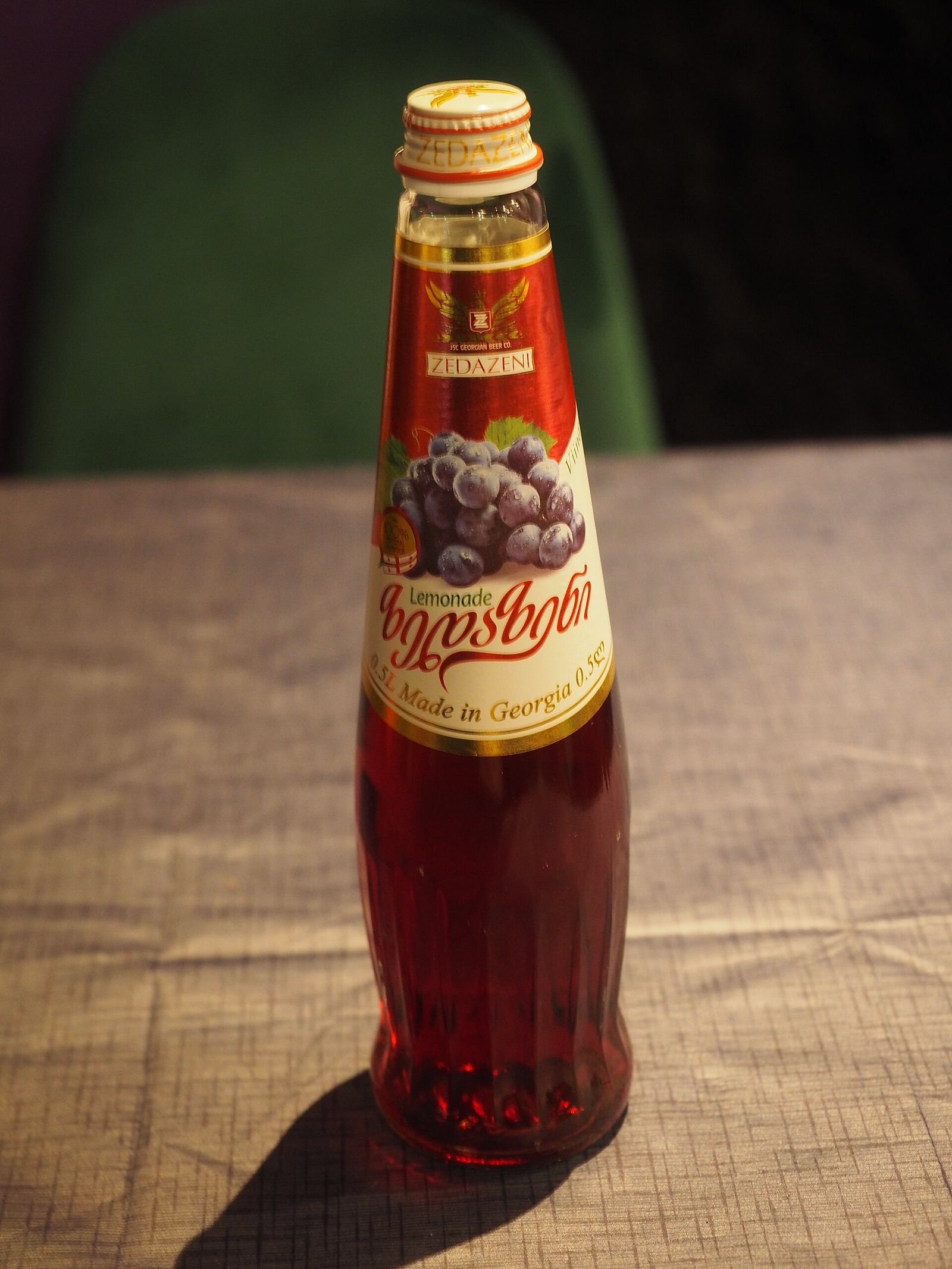 A tall glass bottle of Zedazeni grape lemonade, made in Georgia, with a bunch of grapes on the label