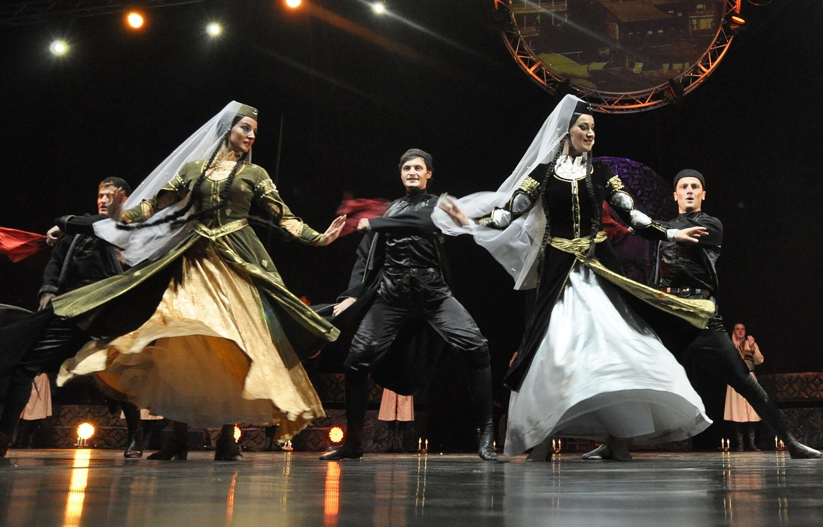 Erisioni dancers on stage, women in long white and gold dresses and veils between men in black chokhas