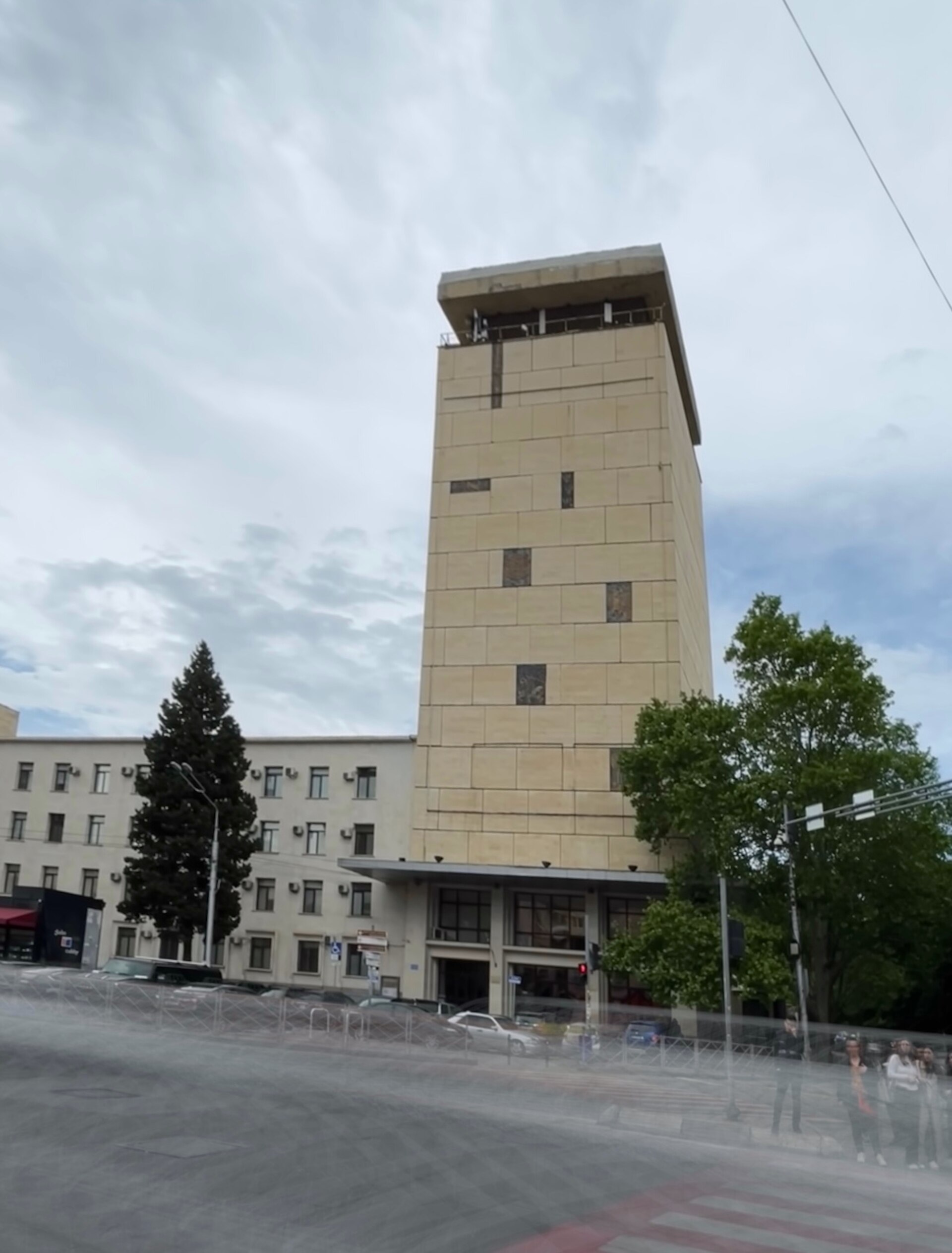 The tall stone-clad tower of the National Archives of Georgia building at 1 Vazha-Pshavela Avenue