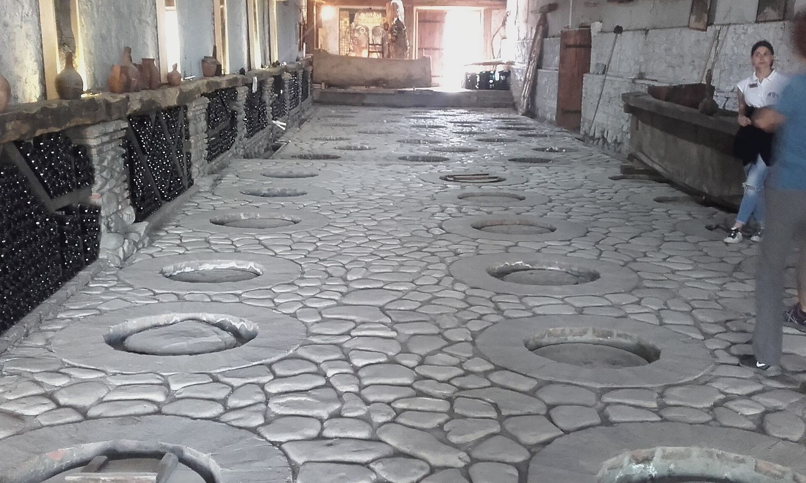Rows of qvevri mouths set into the stone floor of the marani hall at the Kindzmarauli winery in Kakheti