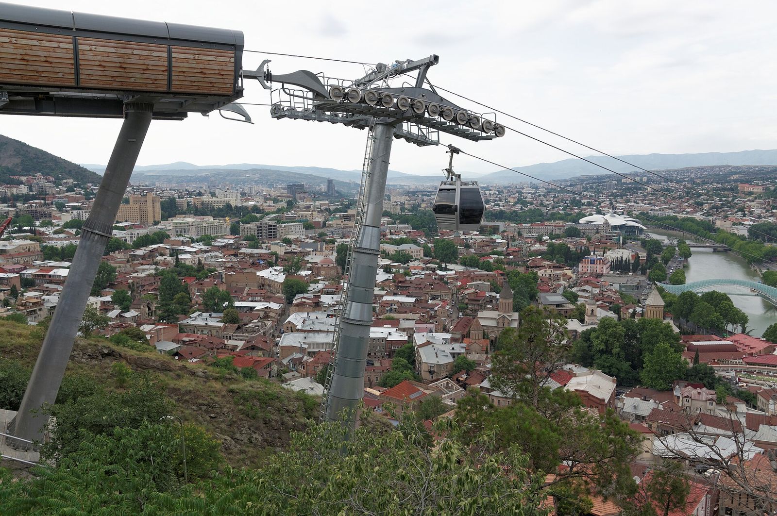 A Rike to Narikala cable car cabin above the old town rooftops of Tbilisi, with the Kura River on the right