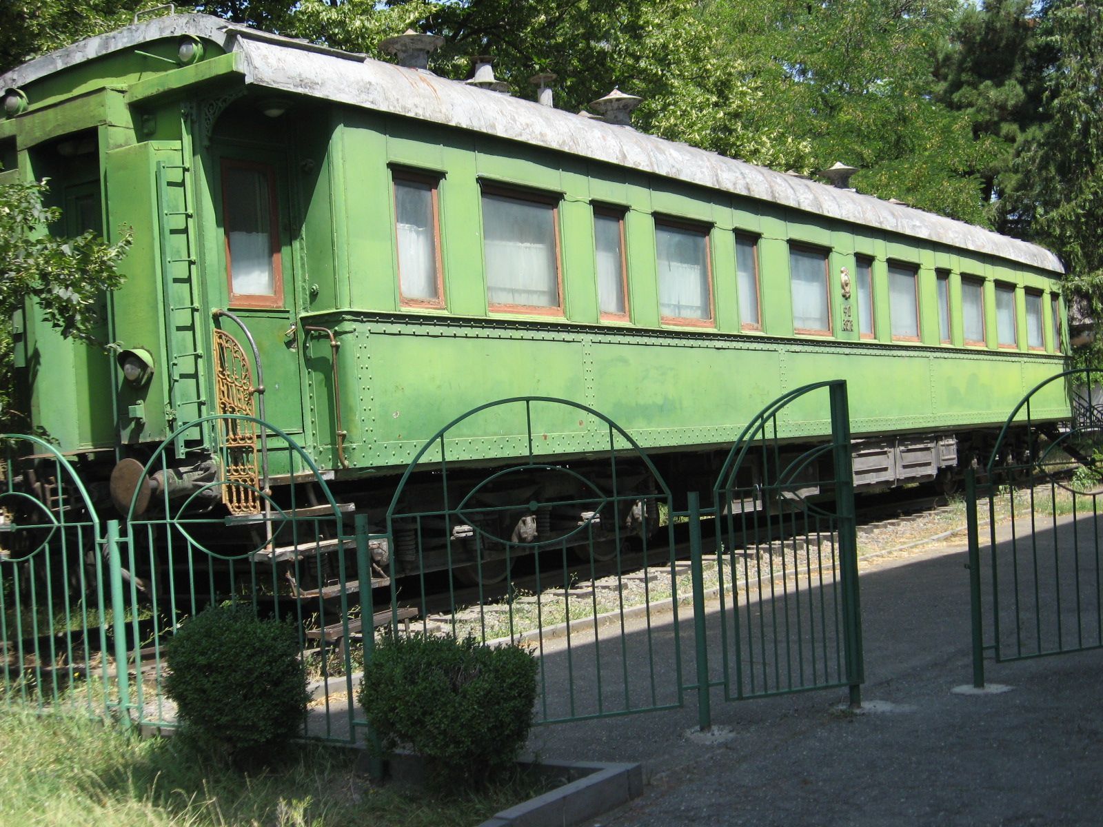 Stalin's green armored railway carriage parked behind an iron fence in the grounds of the Stalin Museum in Gori