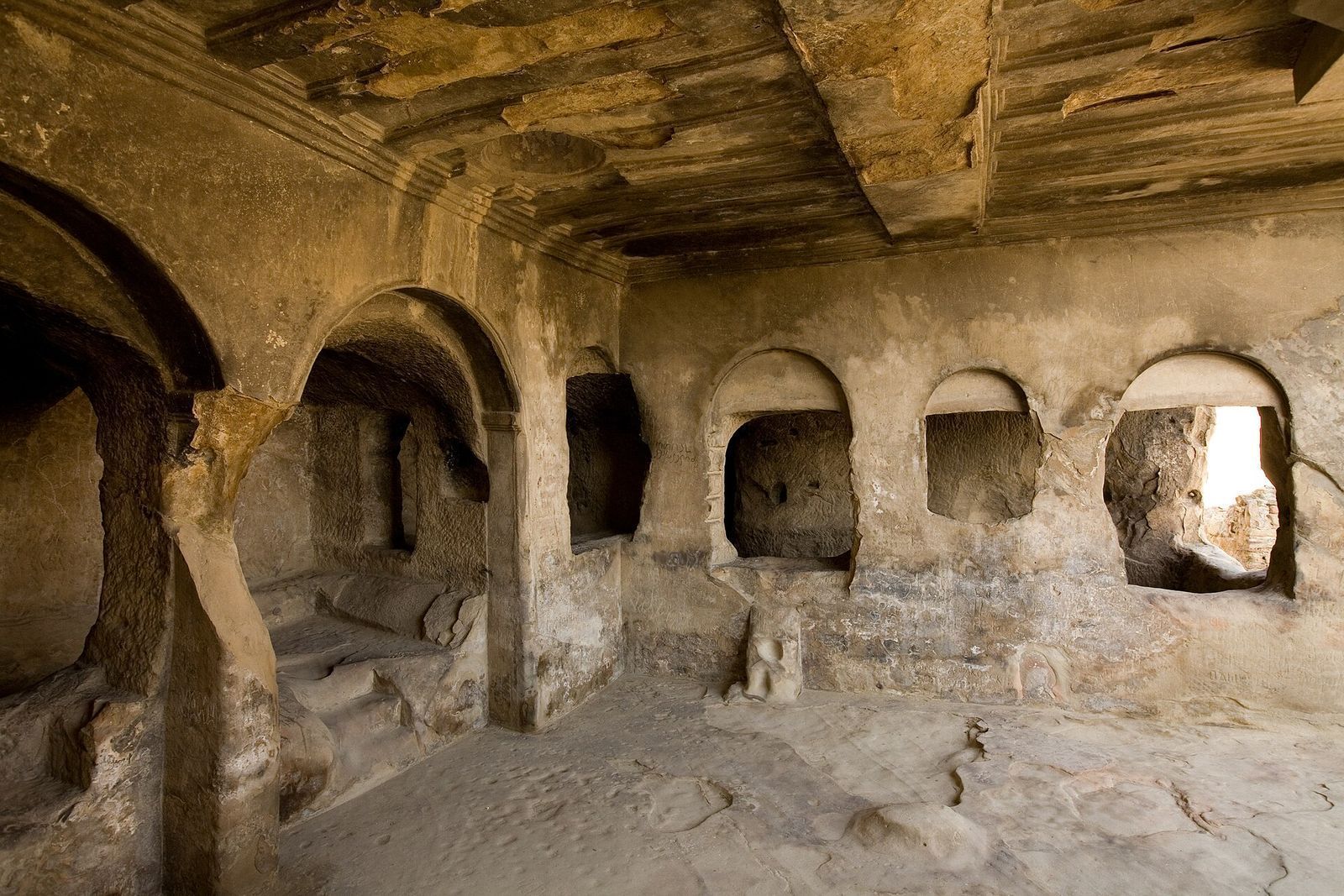 Inside the Hall of Queen Tamar at Uplistsikhe, with arched rock-cut niches and a ceiling carved to look like wooden beams