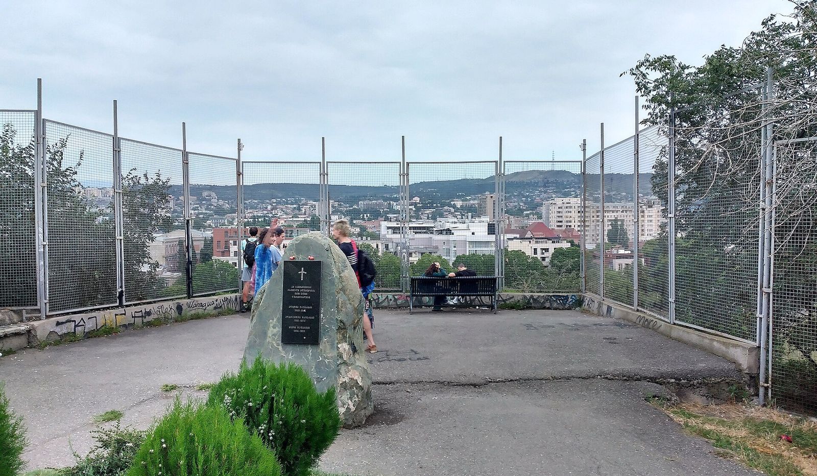 The boulder memorial on the grave of the Japaridze mountaineers at the fenced viewpoint in Vera Park, Tbilisi