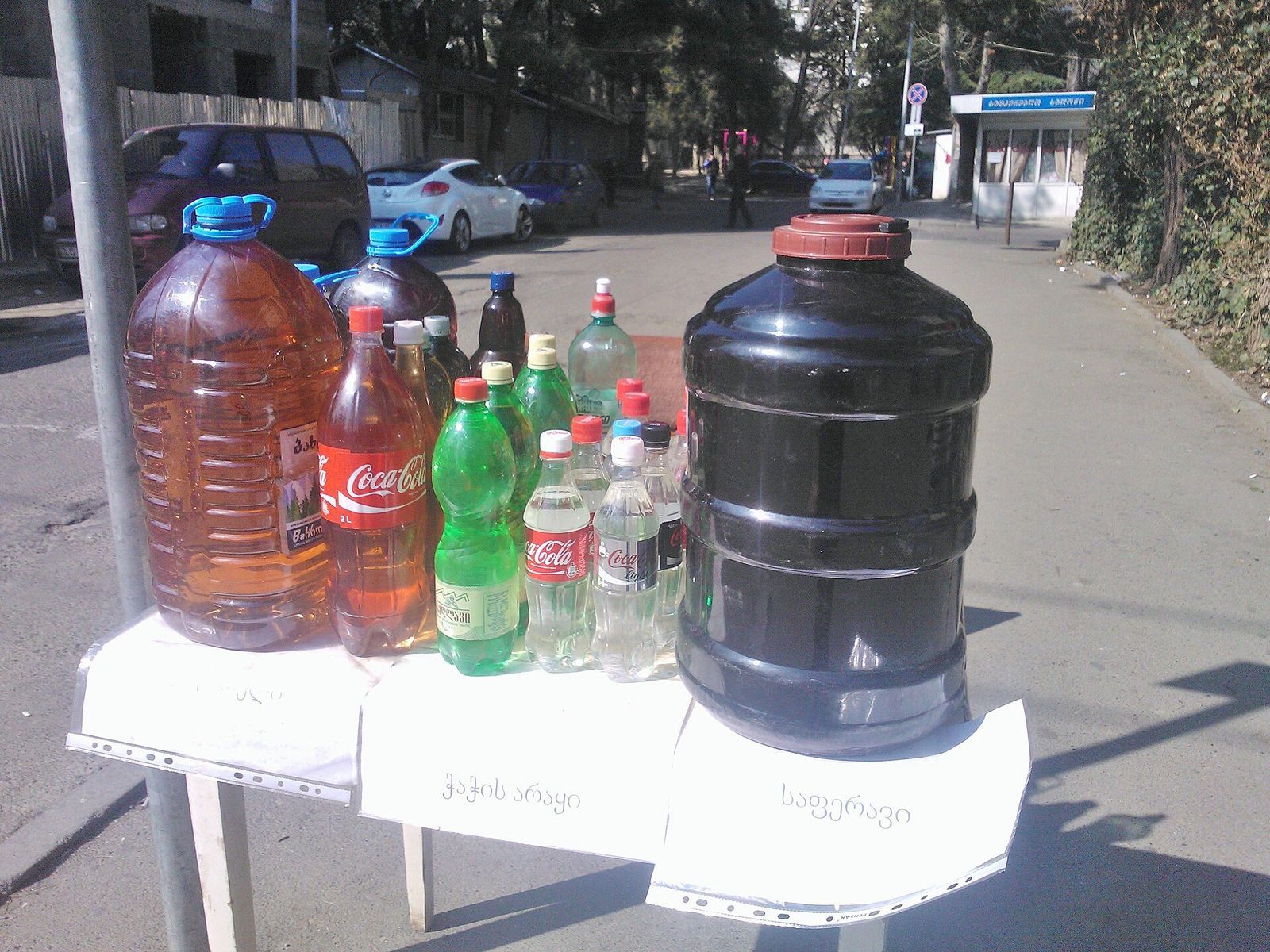 Homemade Saperavi wine and chacha in reused plastic bottles on a street stall in Tbilisi