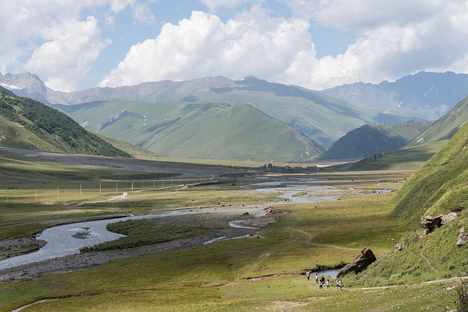The Truso Gorge, a wide green valley with a braided river and walkers on the trail