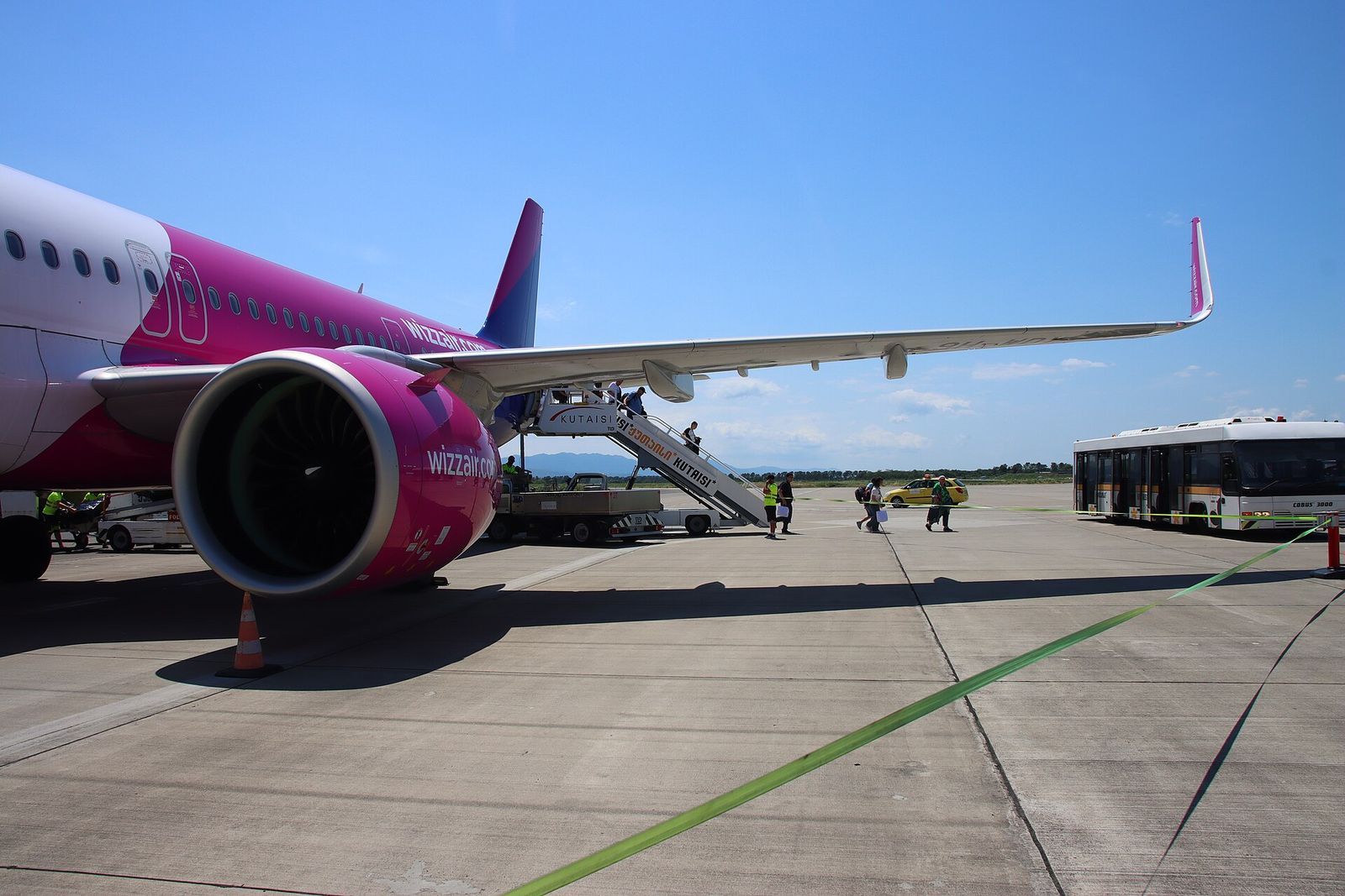 Passengers walking from a Wizz Air plane across the apron at Kutaisi International Airport