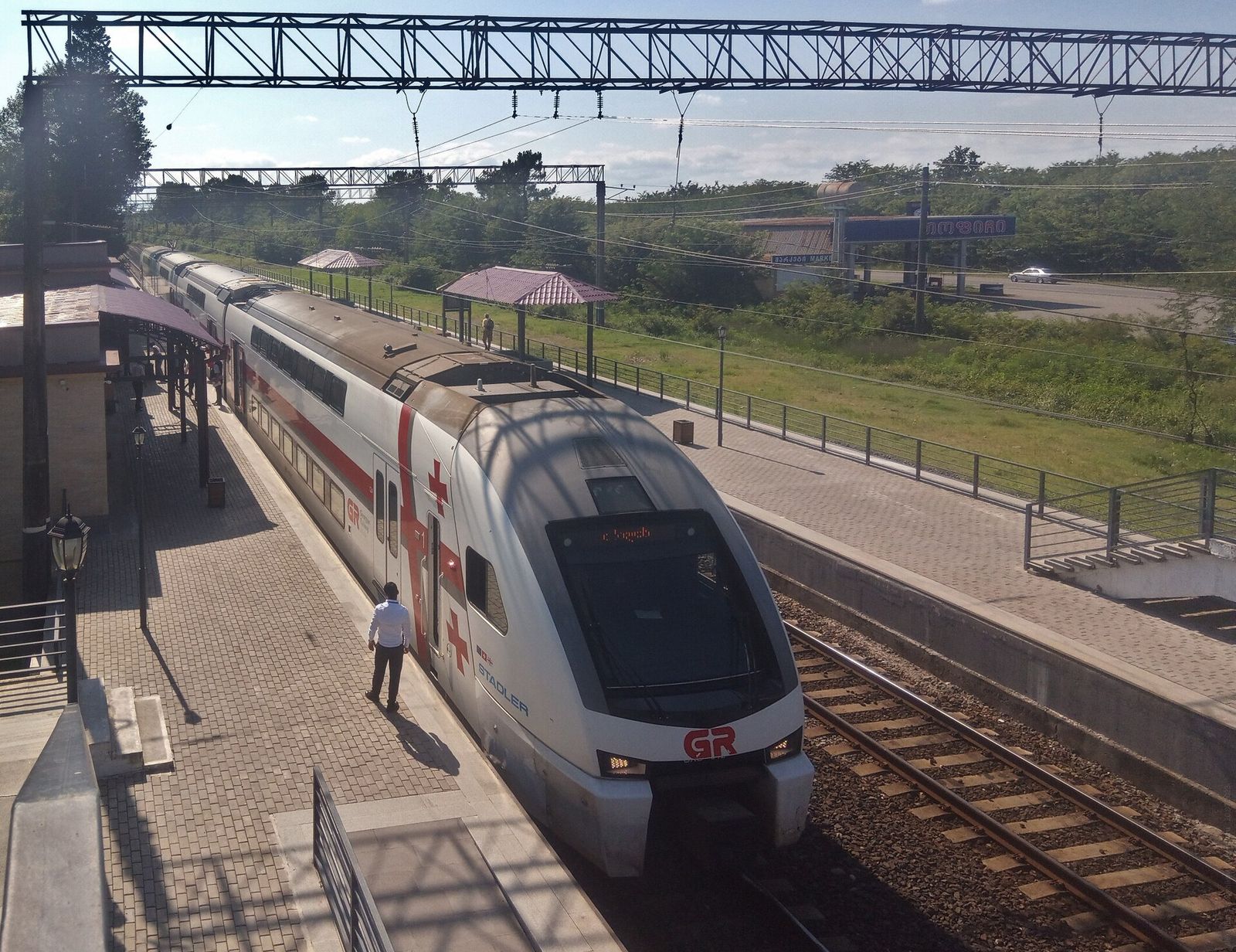A red and white double-deck Stadler train at the Kutaisi International Airport railway station platform