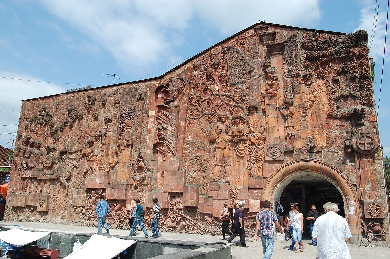 The Kolkhida bas-relief covering the wall of Kutaisi's Green Market, with shoppers at the arched entrance