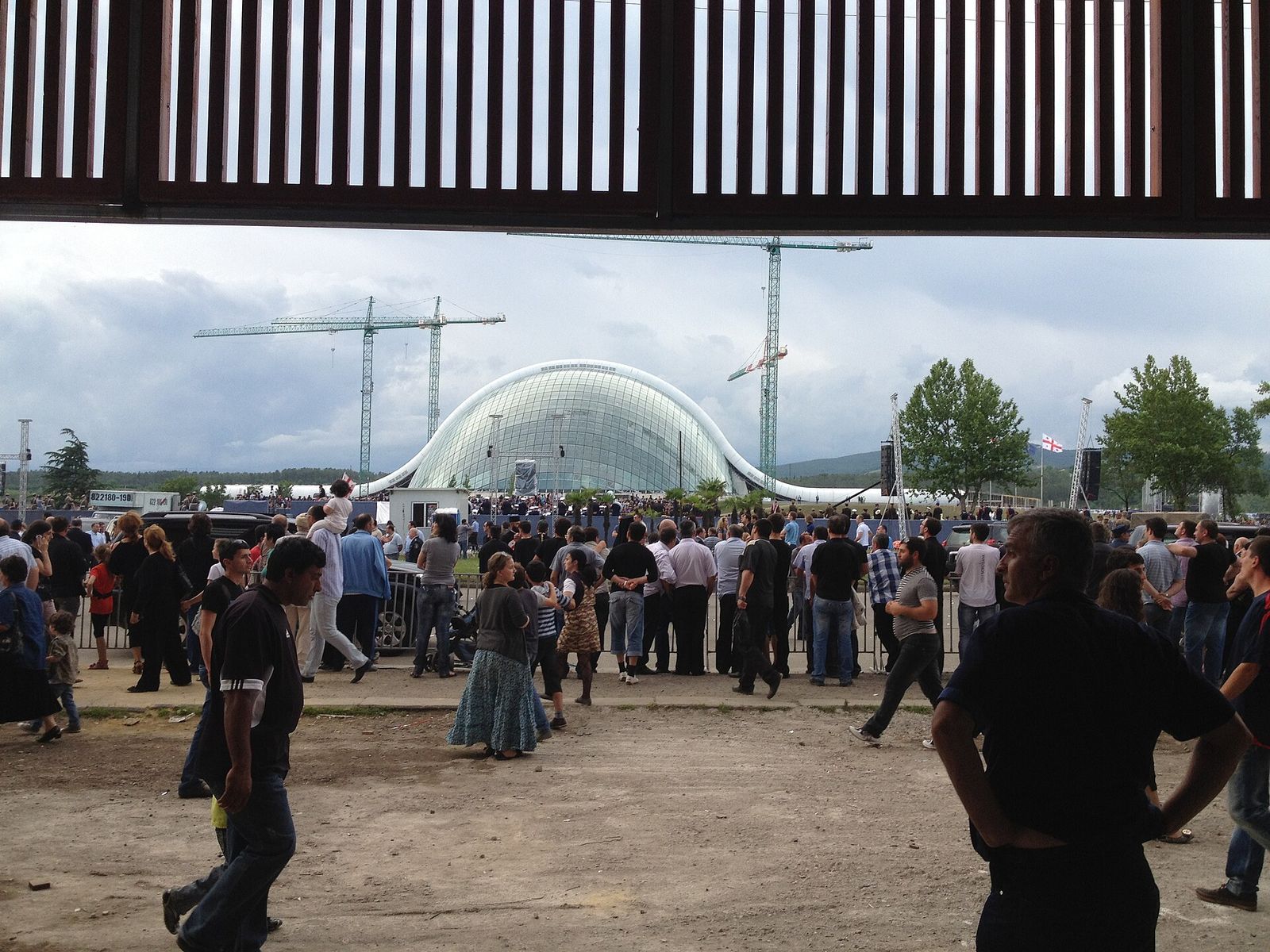 The glass and steel dome of the former Parliament building in Kutaisi, seen beyond a crowd on Independence Day 2012