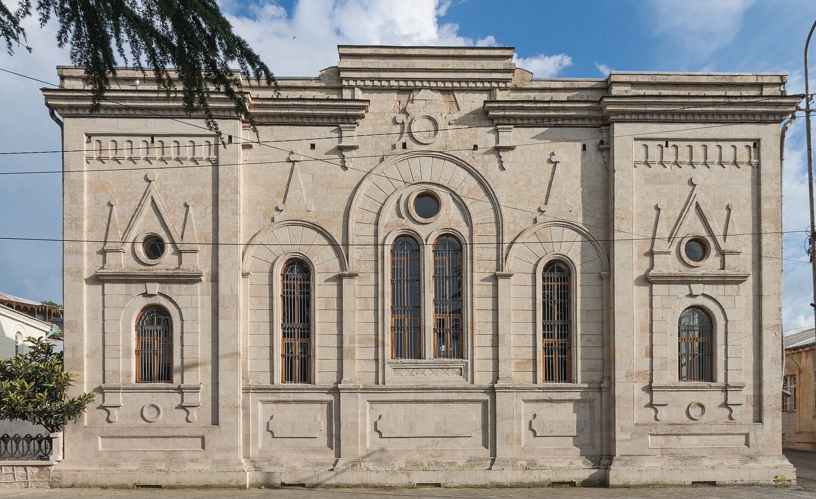 The pale stone front of the Kutaisi Synagogue on Gapanov Street, with its tall arched windows