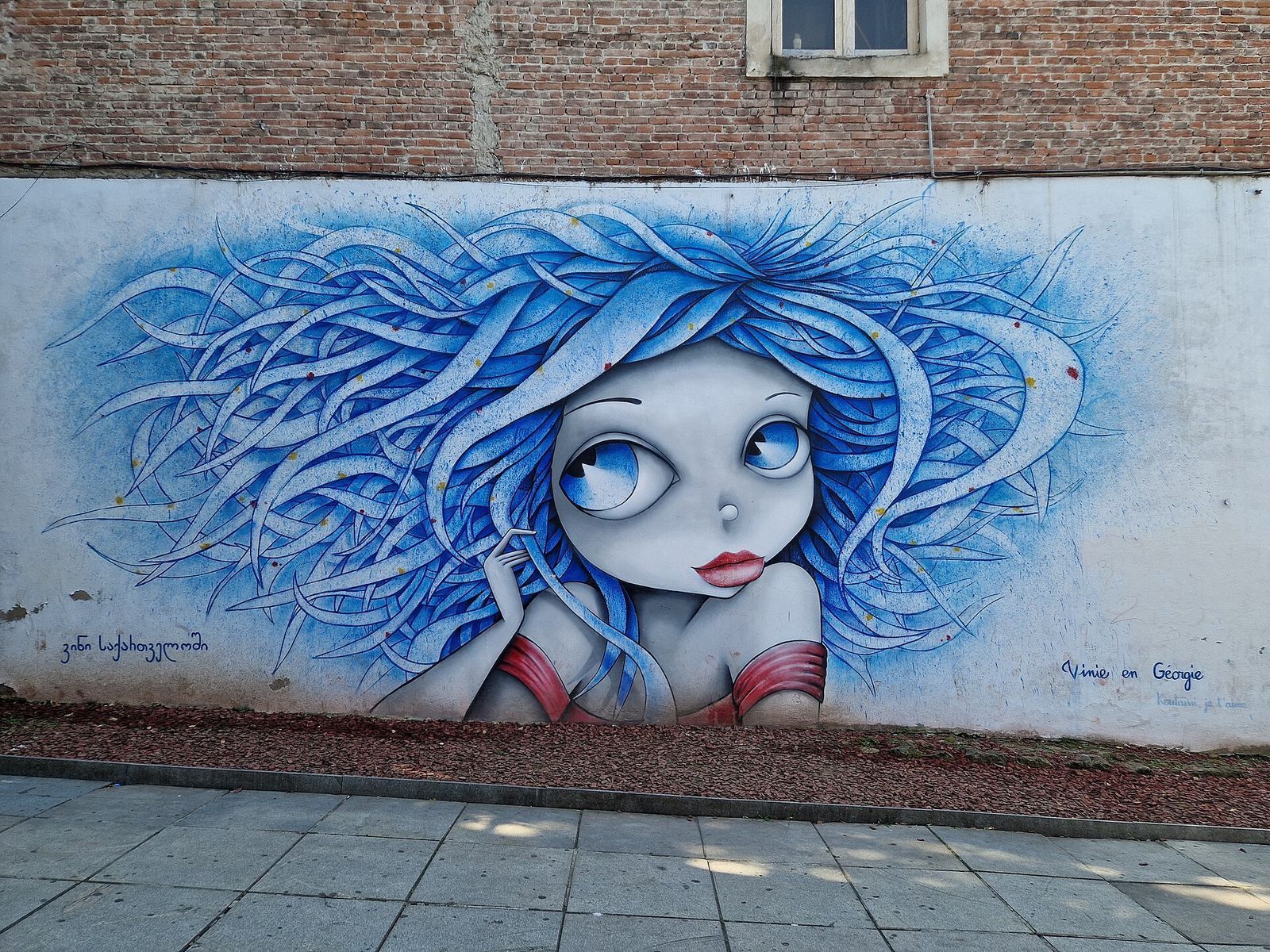 The mural by the French street artist Vinie in central Kutaisi, a girl with big blue eyes and swirling blue hair