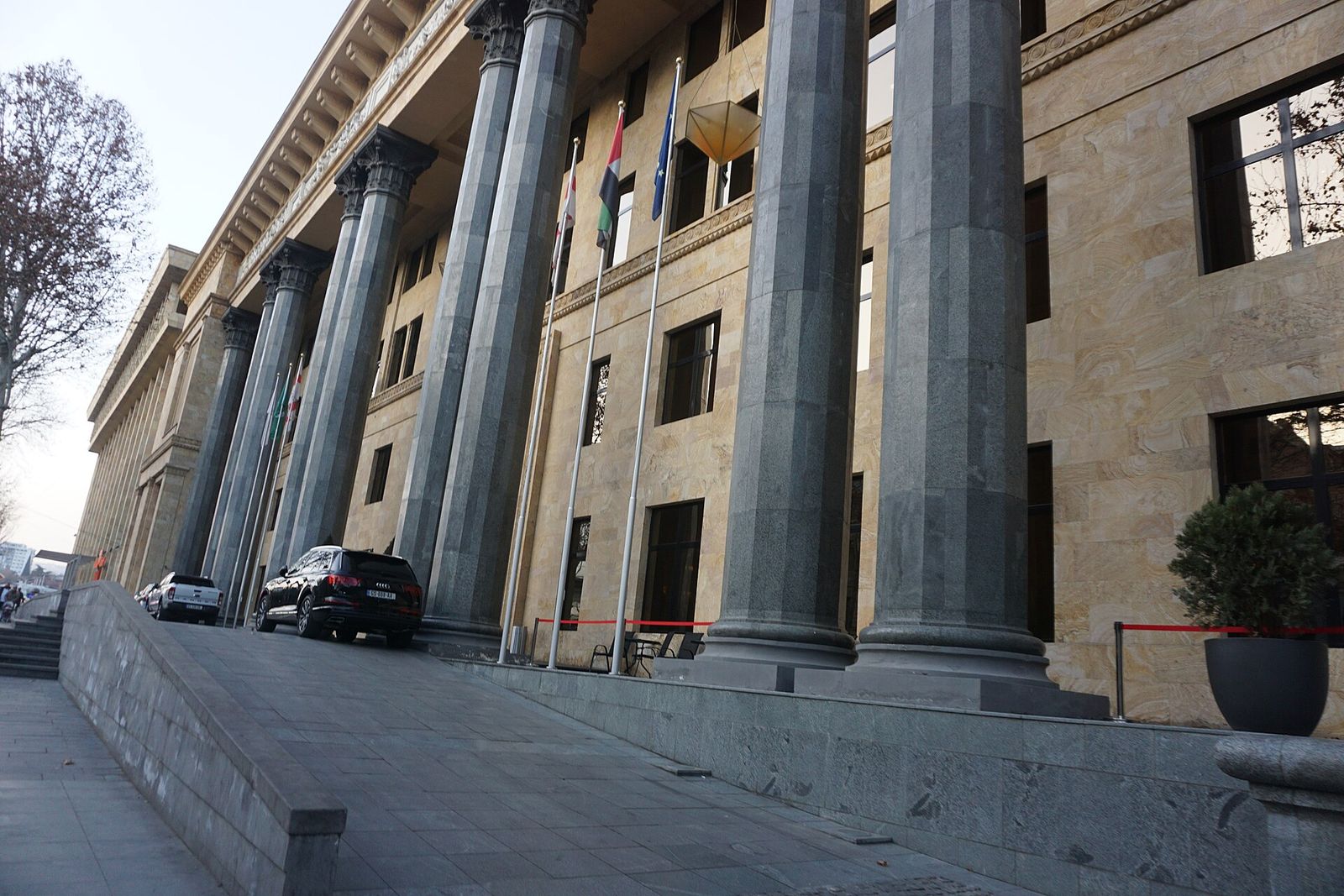 Granite columns and flags at the entrance of the Biltmore Tbilisi in the 1930s IMELI building on Rustaveli Avenue