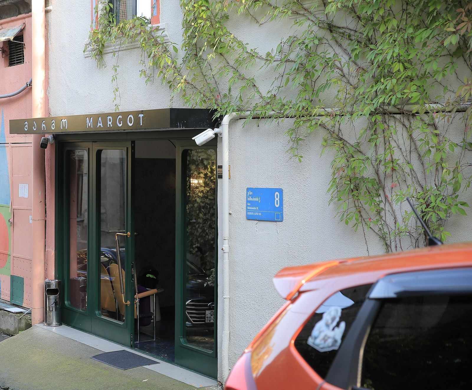 The green glass entrance of Margot Sololaki under its name sign