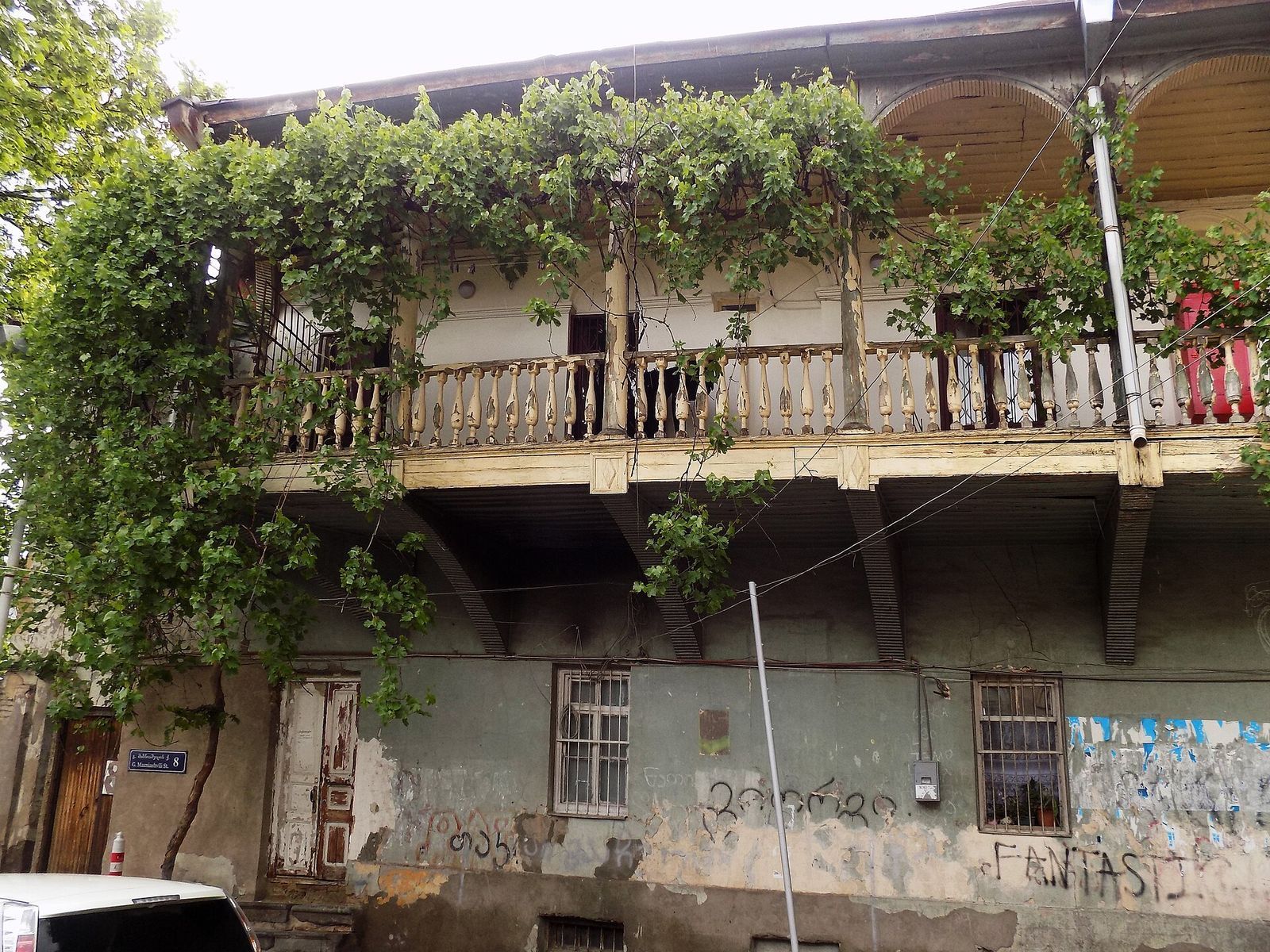An old two-storey house with a vine-covered wooden balcony at 8 Mazniashvili Street, in the German quarter backstreets of Chughureti, Tbilisi