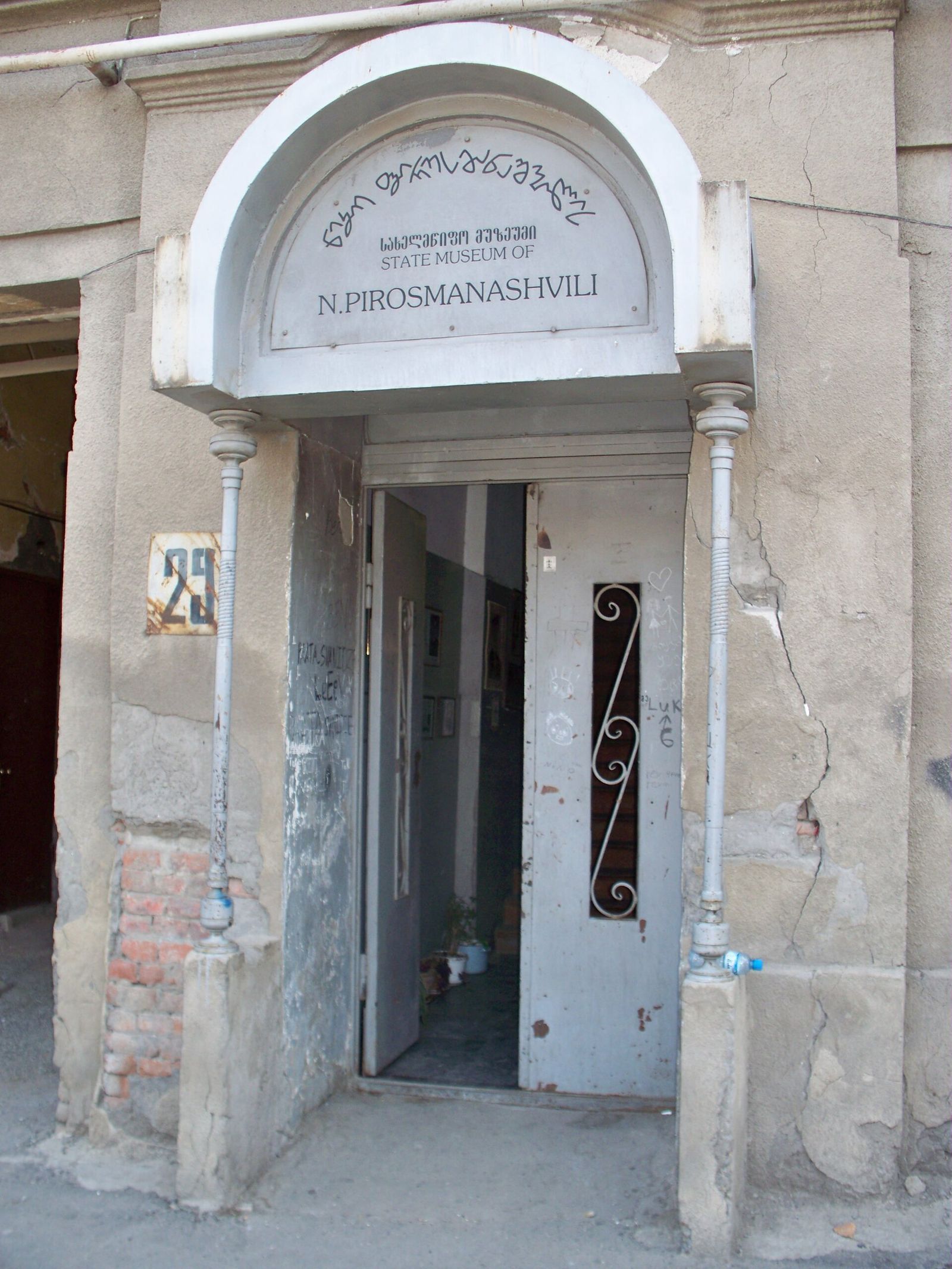 The arched doorway of the Niko Pirosmani house-museum at 29 Pirosmani Street in Chughureti, Tbilisi, with the museum's sign above it