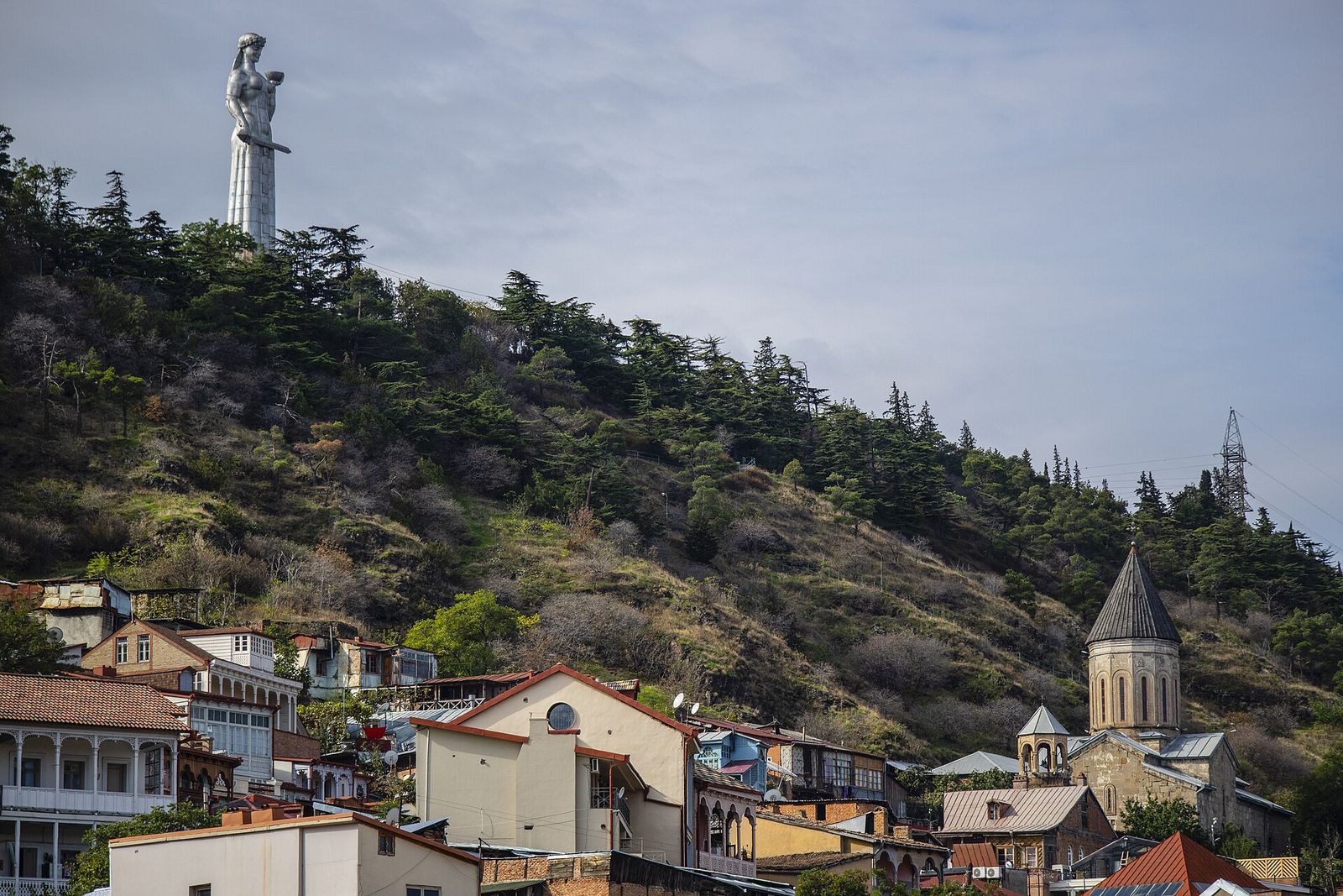 The silver Mother of Georgia statue on the wooded ridge above the rooftops and churches of Old Tbilisi