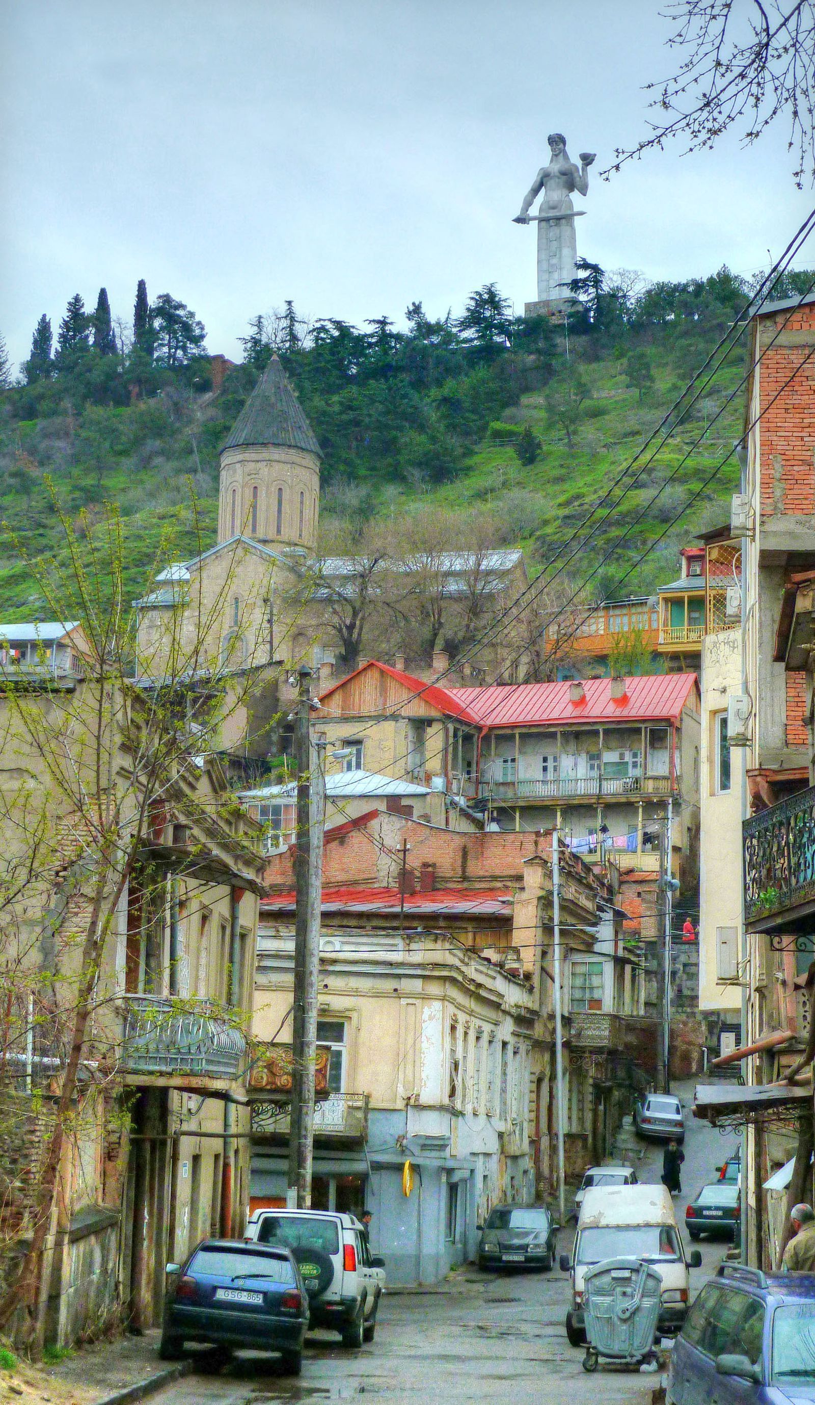 The Mother of Georgia statue towering over a narrow Betlemi street, a church and the old houses of the neighborhood