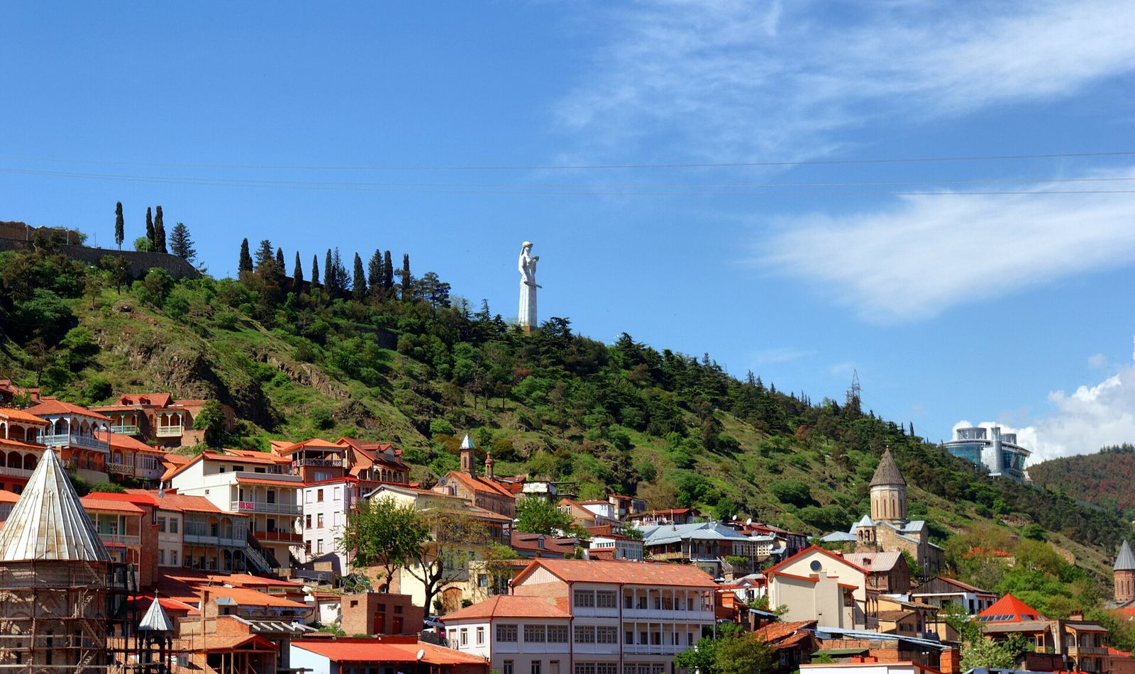The Mother of Georgia statue on the green ridge above the balconied houses and churches of the Old Town, seen from Metekhi Church