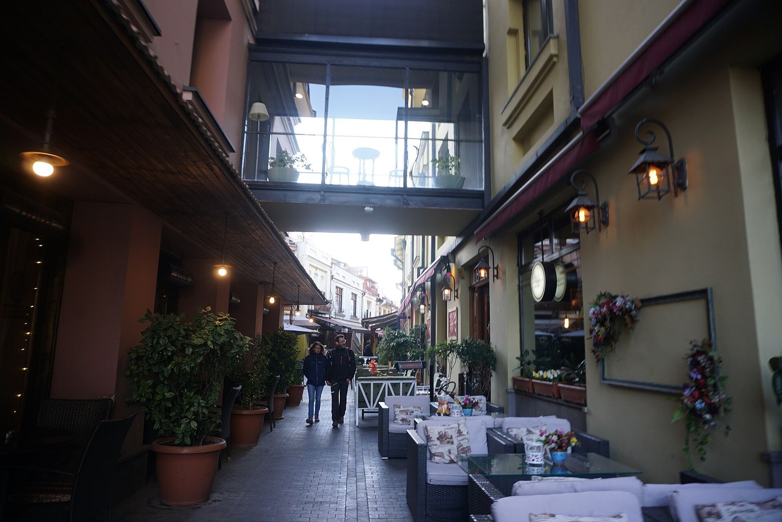 Shardeni Street in Old Tbilisi with outdoor terrace seating, lanterns and a glass skyway linking the buildings overhead