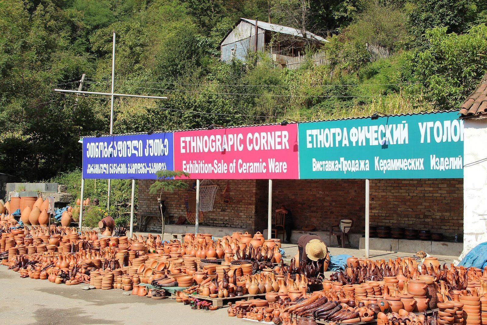 Roadside pottery stalls in Shrosha, Imereti, lined with clay jugs, pots and jars under an Exhibition-Sale of Ceramic Ware sign