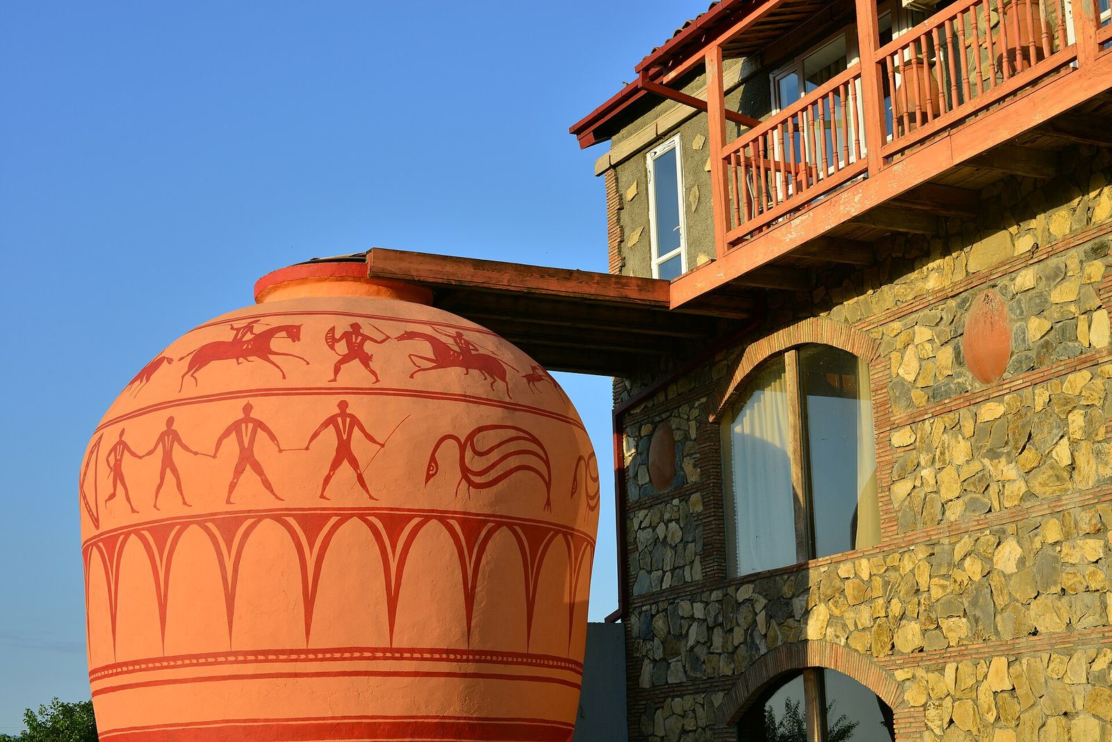 A giant painted qvevri beside the stone wine house at Twins Old Cellar in Napareuli, Kakheti