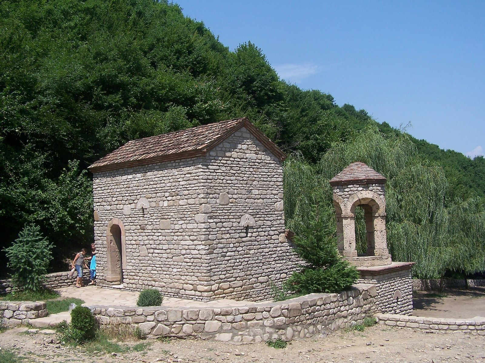 The small stone chapel and arched bell tower over St. Nino's spring in the woods below Bodbe Monastery