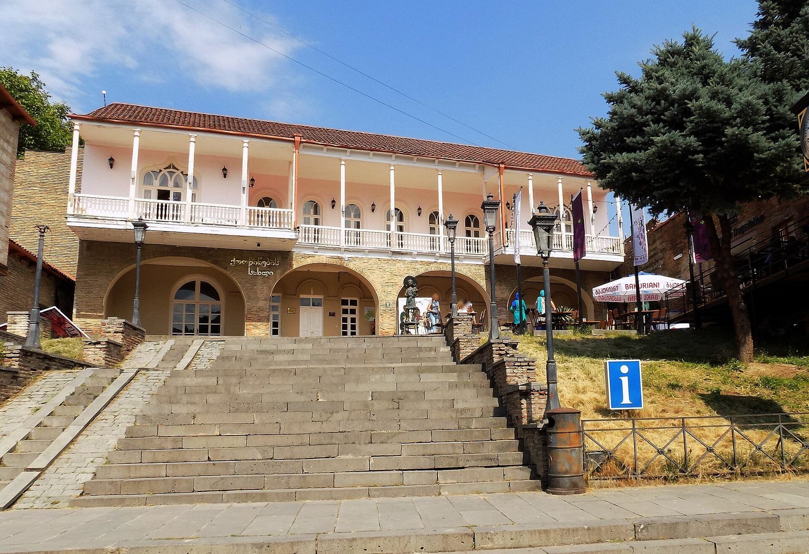 Sighnaghi's wedding house, a two-storey building with a white columned balcony above stone arches, at the top of a wide flight of stone steps