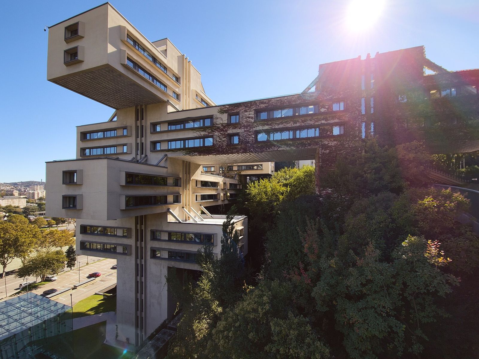 The Bank of Georgia headquarters, the former Ministry of Highway Construction, its concrete blocks cantilevered over trees on a slope in Tbilisi