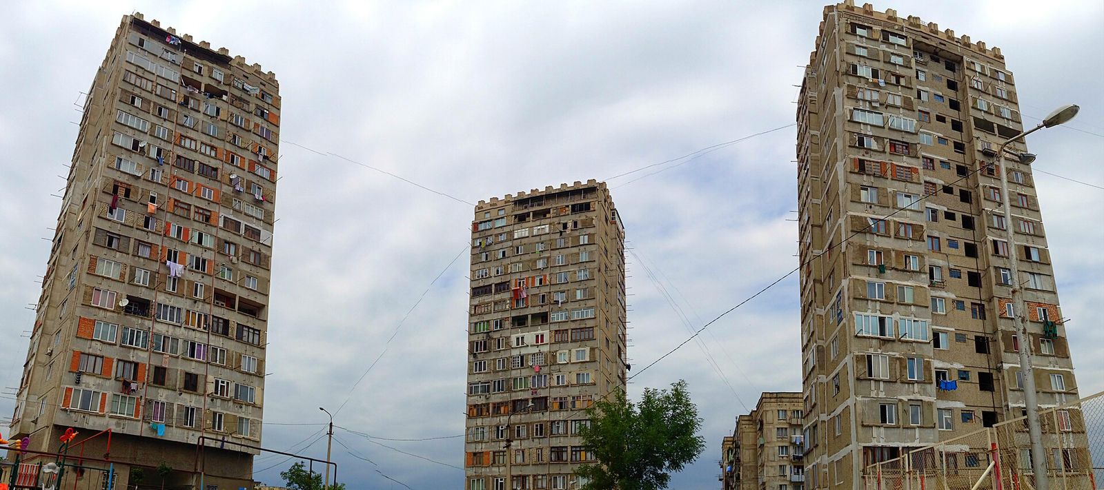 Three tall Soviet-era apartment towers on the Nutsubidze Plateau in Tbilisi, with laundry hanging from the balconies