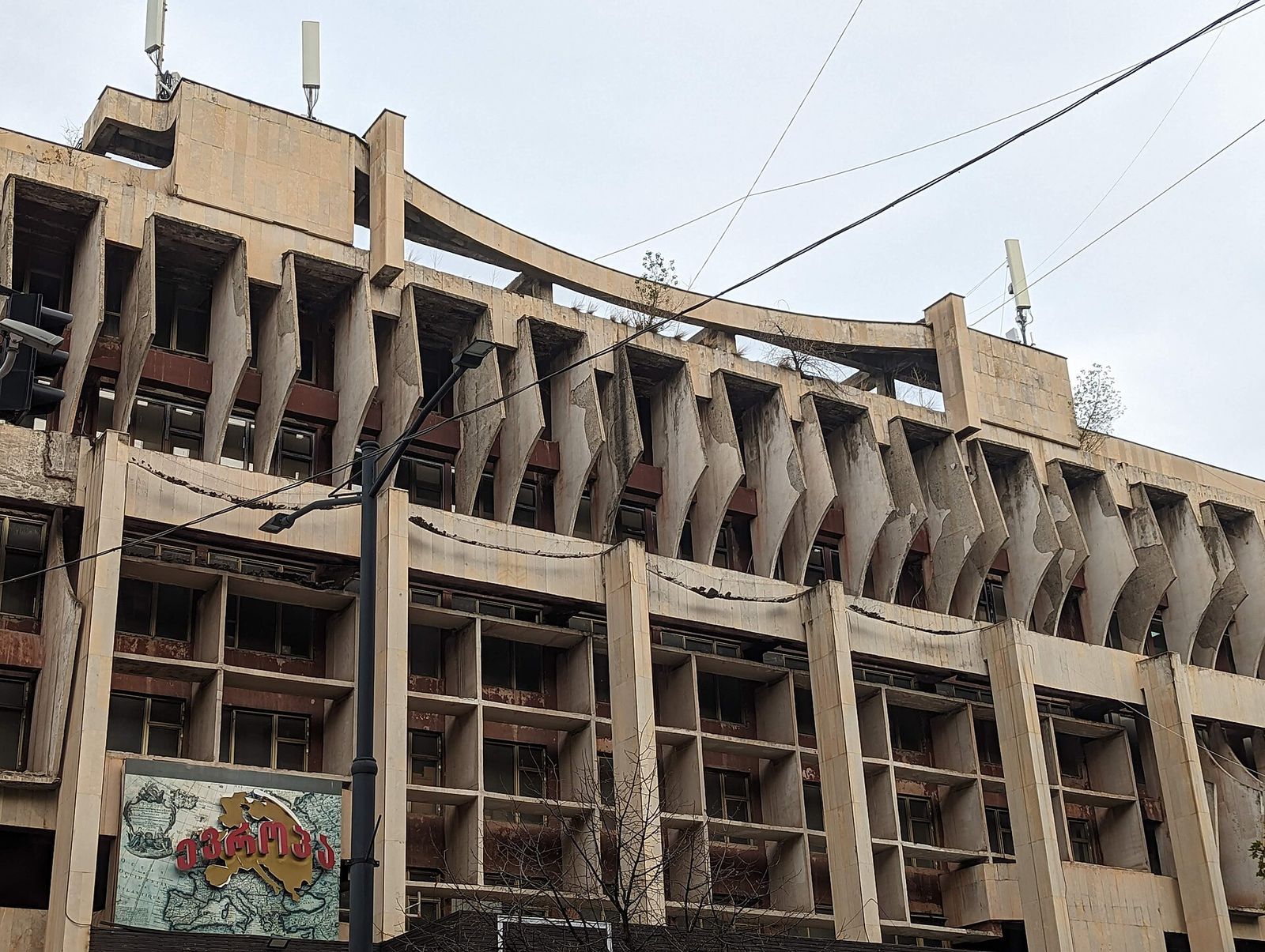 The weathered brutalist facade of the former Scientific Technical Library building on Merab Kostava Street, lined with angled concrete fins