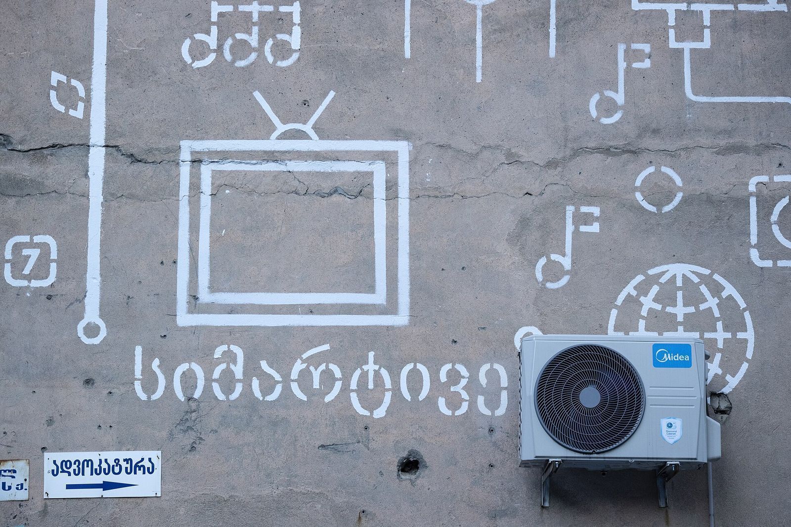 White painted symbols and Georgian lettering on a concrete wall at Vake Park