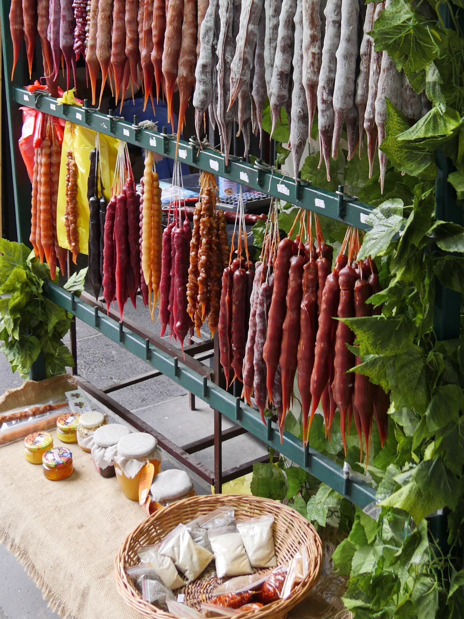 Strings of red, orange and purple churchkhela hanging at a market stall in Tbilisi
