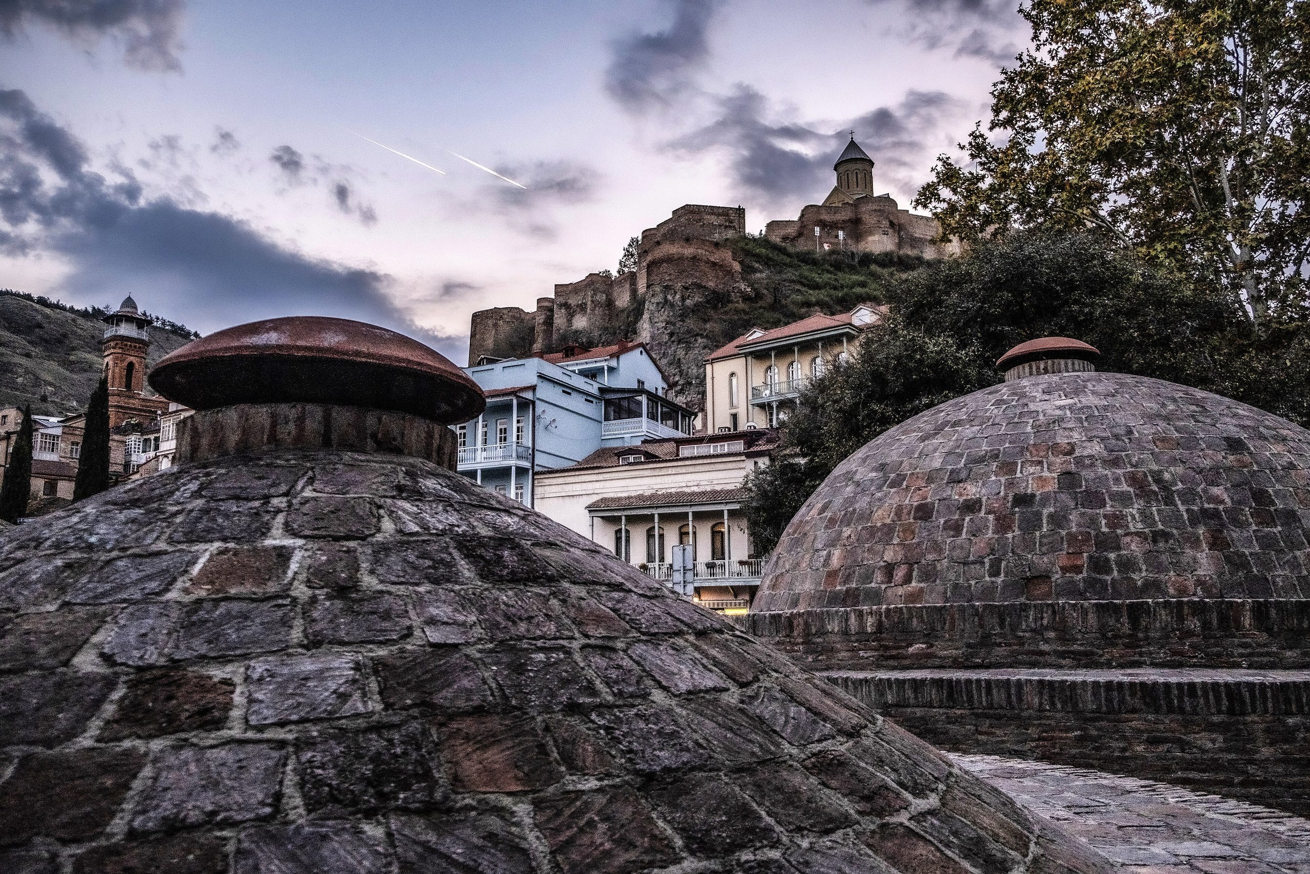Brick domes of the sulfur baths in Abanotubani, with Narikala fortress on the hill behind