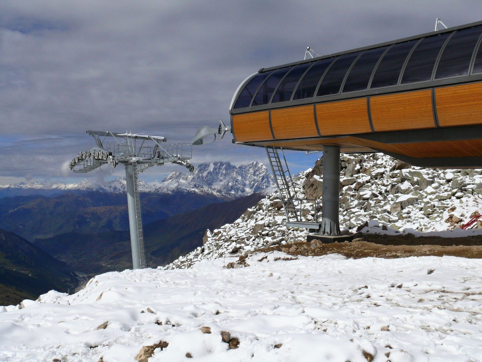 The upper chairlift station of the Tetnuldi ski area at about 3,050 m, with fresh snow on the rocks and Caucasus peaks across the valley