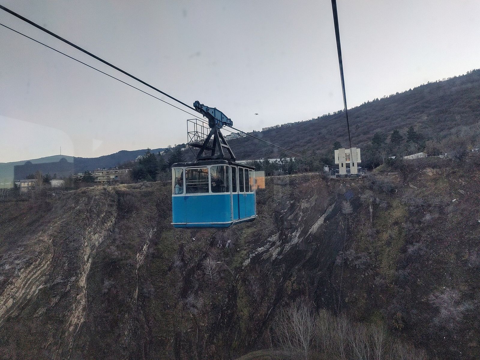 The blue gondola of the Bagebi cable car crossing the Vere River gorge between Tbilisi State University and Bagebi