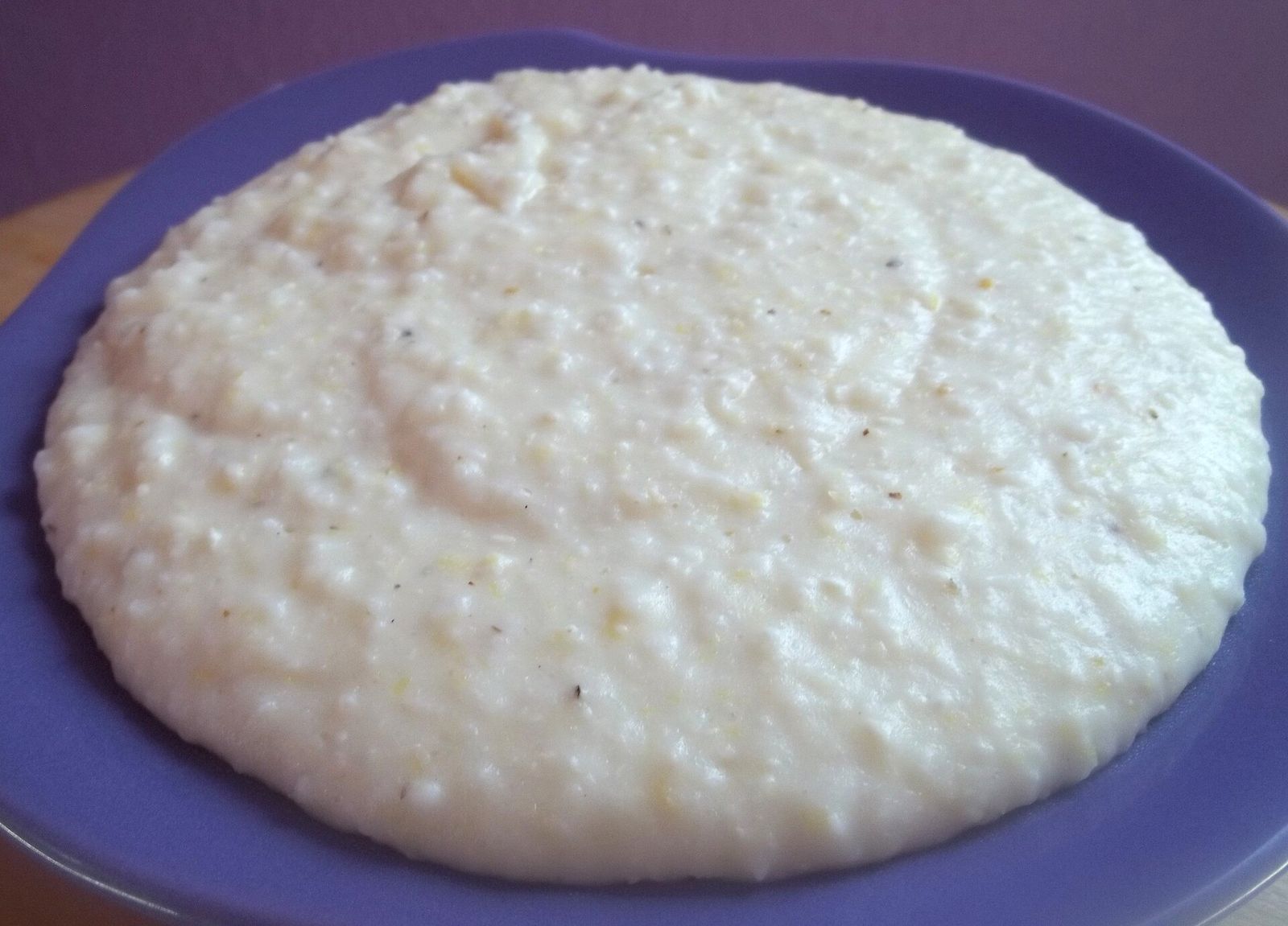Elarji, cornmeal cooked with sulguni cheese, spread on a blue plate