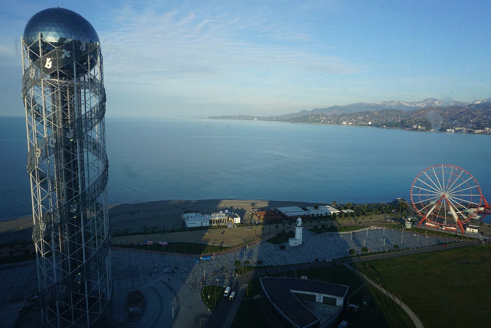 The Alphabet Tower and a Ferris wheel on the Batumi seafront, with the Black Sea and the coast behind