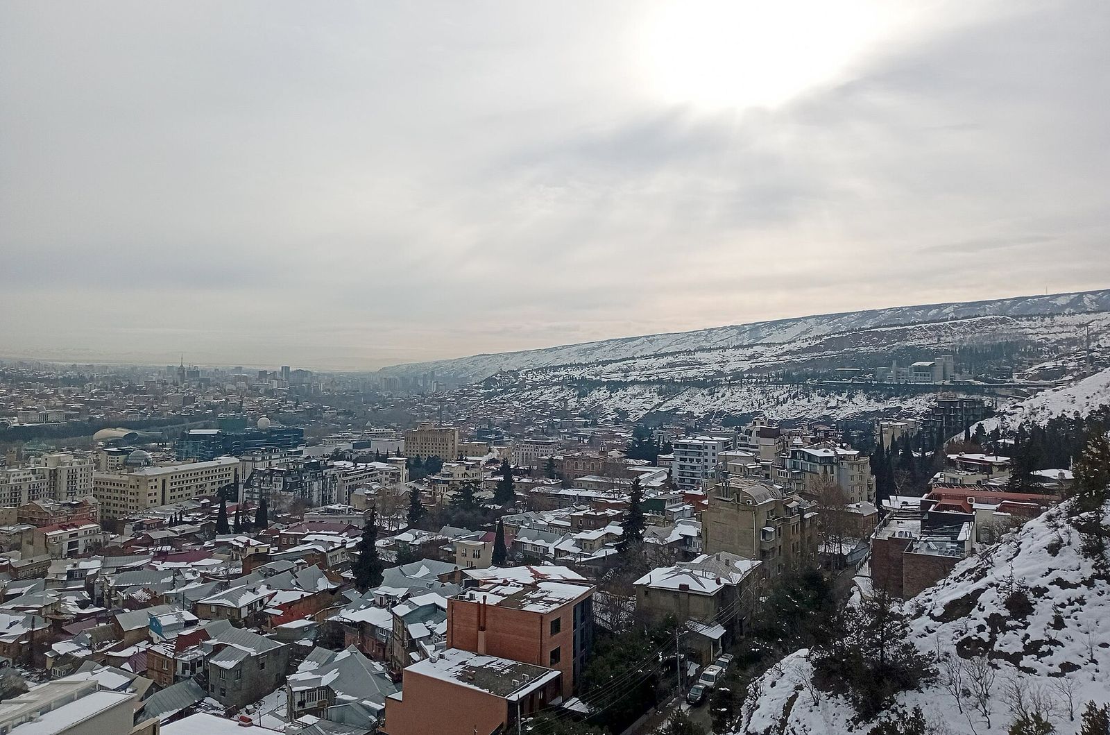 Cityscape of Mtatsminda neighbourhood of Tbilisi from a viewpoint on a hiking path above Polikarpe Kakabadze Street, taken several days after a record